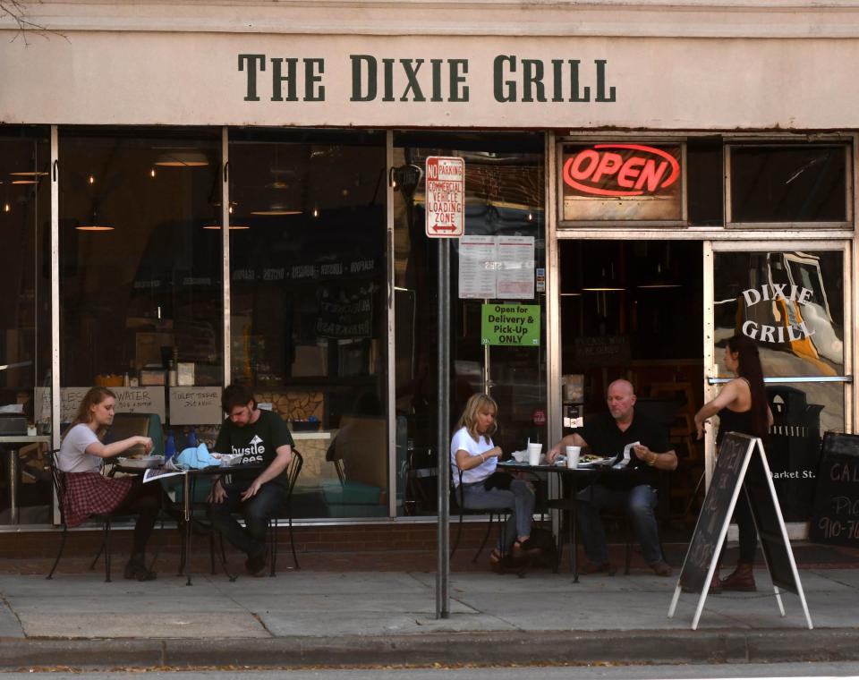 Customers eat lunch outside of The Dixie Grill Friday March 20, 2020 in Wilmington, N.C.  [KEN BLEVINS/STARNEWS]