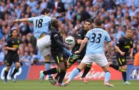 Wigan Athletic's Arouna Kone (centre) and Manchester City's Gareth Barry battle for the ball
