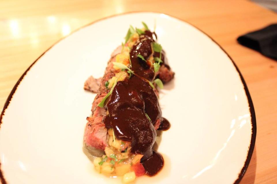 Pork Mole Negro, a 10 ounce pork flank topped with Oaxacan mole negro, truffle huitlacoche foam, and grilled peach chutney, apart of the Destination Oaxaca limited time menu at Toro Toro Fort Worth.