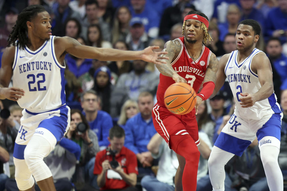 Louisville's El Ellis (3) passes away from Kentucky's Sahvir Wheeler (2) and Cason Wallace (22) during the second half of an NCAA college basketball game in Lexington, Ky., Saturday, Dec. 31, 2022. Kentucky won 86-63. (AP Photo/James Crisp)