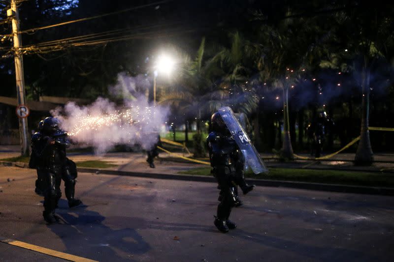 Police officers react as people protest after a man, who was detained for violating social distancing rules, died from being repeatedly shocked with a stun gun by officers, according to authorities, in Bogota