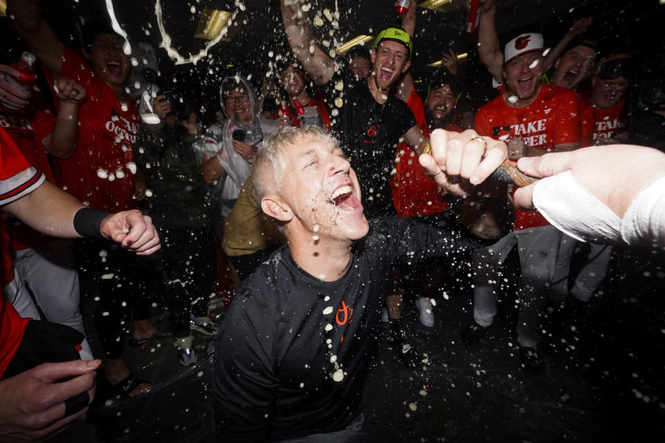 Baltimore Orioles general manager Mike Elias drinks from the "Homer Hose" during a locker room celebration after the Orioles defeated the Tampa Bay Rays 5-4 in 11 innings of a baseball game to clinch a postseason spot, Sunday, Sept. 17, 2023, in Baltimore. (AP Photo/Julio Cortez)
