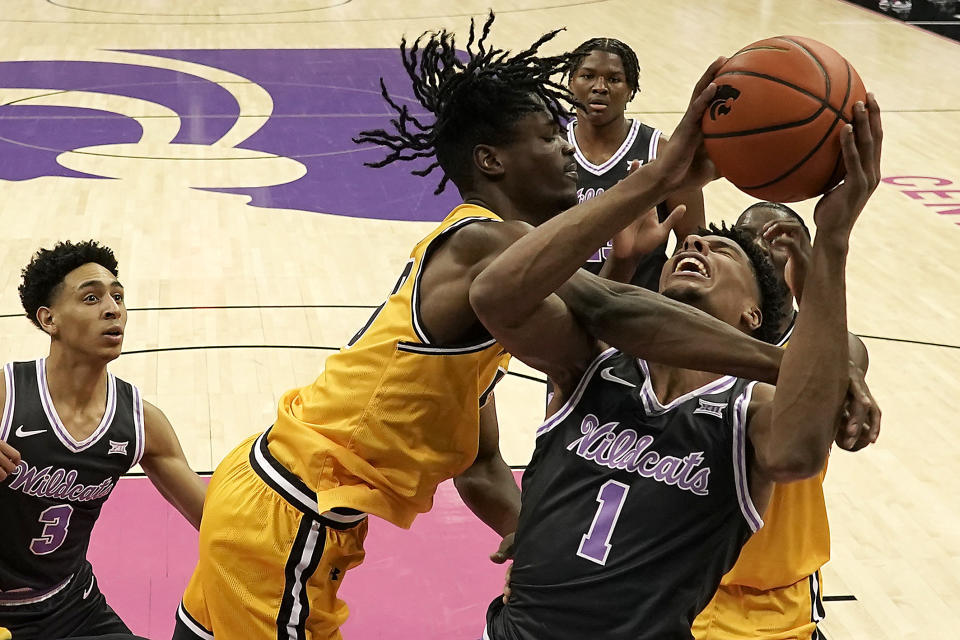 Wichita State forward Isaac Abidde, center, blocks a shot by Kansas State forward David N'Guessan (1) during the first half of an NCAA college basketball game Thursday, Dec. 21, 2023, in Kansas City, Mo. (AP Photo/Charlie Riedel)