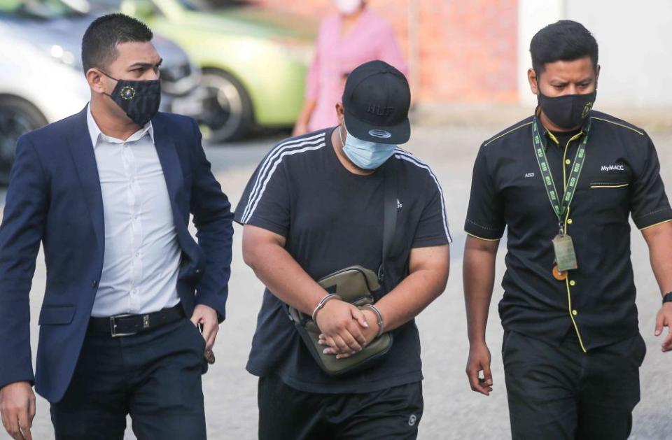 Policeman Mohd Iqbal Fakhruddin Roslan (centre) is pictured at the Ipoh Sessions Court February 24, 2021. — Picture by Farhan Najib