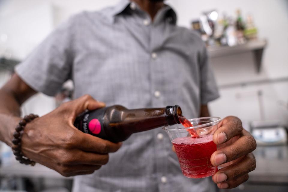 Dwayne Allen, founder of Big Marble Organics, pours samples of Proper Hibiscus at the company's production facility in Phoenix on July 11, 2023.