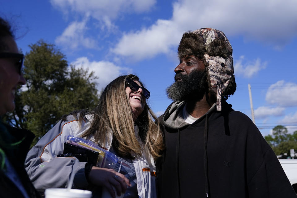 Glori Coronati, left, talks with Jomo, last name withheld, as he receives goods like needles, tourniquets, food and Naloxone to participants on Monday, Jan. 23, 2023, in Albany, Ga. Jomo, who uses illegal drugs, said he's glad for the supplies. “Because this is something we’re going to do anyway,” he said. (AP Photo/Brynn Anderson)