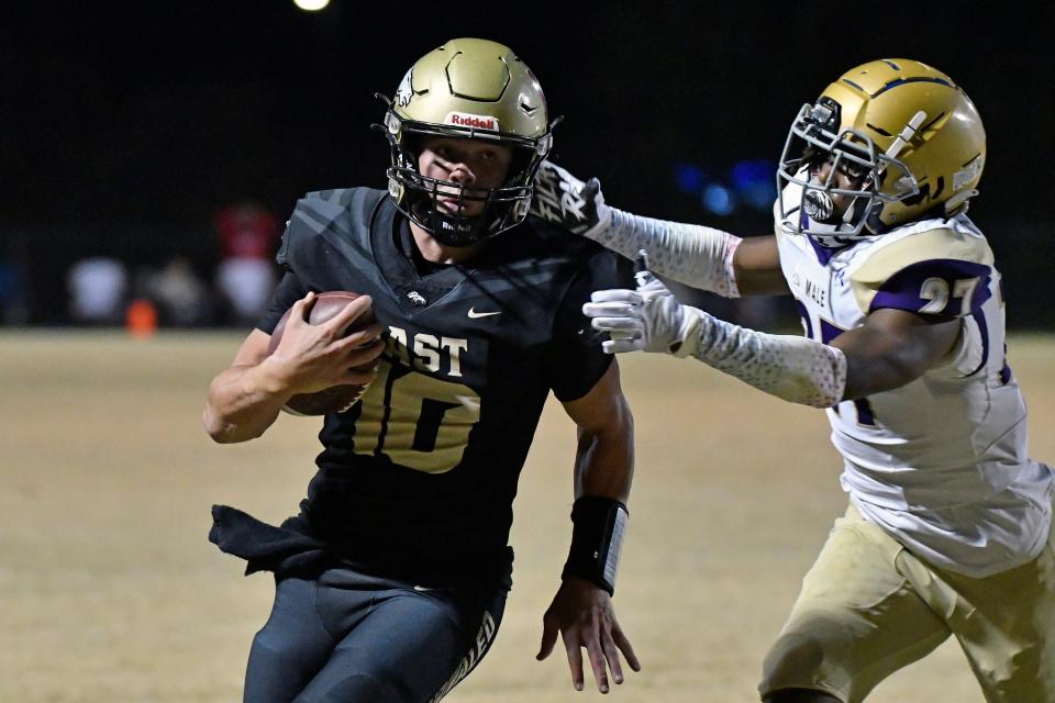 Bullitt East's Travis Egan runs from the tackle attempt from Male’s Kevin Wilson (27) during action of their game, Friday, Oct. 21 2022 in Mt. Washington Ky.