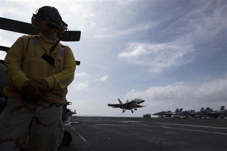 A U.S. Navy F/A-18 aircraft prepares to land on the runway of the U.S. Navy aircraft carrier USS George Washington, during a tour of the ship in the South China Sea November 7, 2013. REUTERS/Tyrone Siu