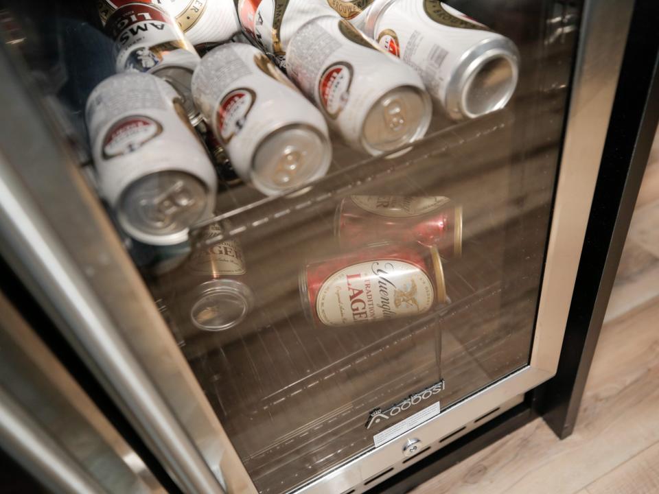 The refrigerator with cans of beer.