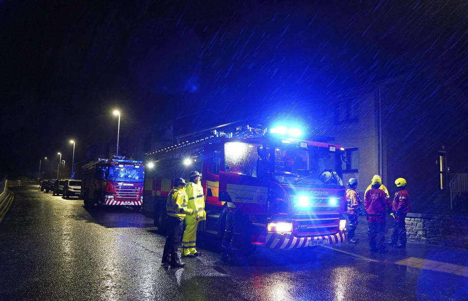 Emergency services in Stonehaven, Scotland, knock on doors and ask residents to evacuate due to flood warnings, Thursday, Oct. 19, 2023. Hundreds of people are being evacuated from their homes and schools have closed in parts of Scotland, as much of northern Europe braces for stormy weather, heavy rain and gale-force winds from the east. The U.K.’s weather forecaster, the Met Office, issued a rare red alert, the highest level of weather warning, for parts of Scotland. (Andrew Milligan/PA via AP)