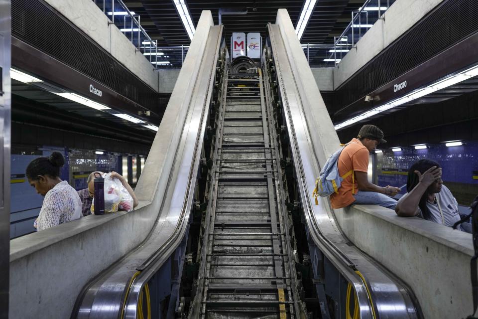 FILE - A subway escalator sits in disrepair as commuters wait for a subway train in Caracas, Venezuela, Oct. 3, 2023. (AP Photo/Matias Delacroix, File)