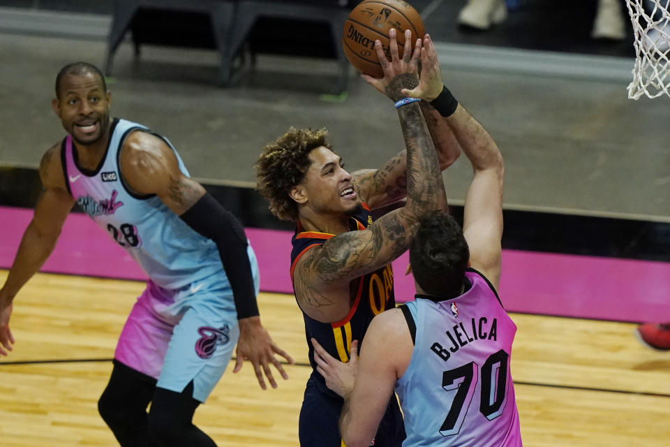 Miami Heat forward Nemanja Bjelica (70) defends against Golden State Warriors guard Kelly Oubre Jr. (12), during the first half of an NBA basketball game, Thursday, April 1, 2021, in Miami. (AP Photo/Marta Lavandier)