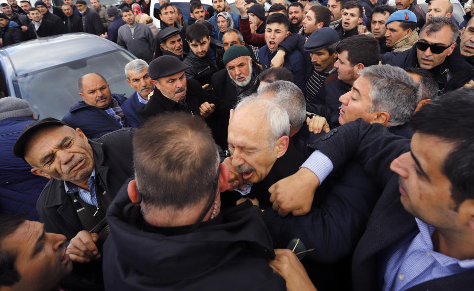 FILE - A man punches Kemal Kilicdaroglu, the leader of Turkey's main opposition Republican People's Party, CHP, outside Ankara, Turkey, on Sunday, April 21, 2019, during the funeral of a soldier killed during clashes with Kurdish rebels at the Iraq border. Kilicdaroglu is the main challenger to Turkish President Recep Tayyip Erdogan in the May 14 presidential election, and he cuts a starkly different figure than the incumbent who has led the country for two decades. As the polarizing Erdogan has grown increasingly authoritarian, Kilicdaroglu has a reputation as a bridge builder and vows to restore democracy. (DHA via AP, File)