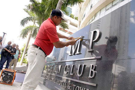 A worker removes the Trump name from the Trump Ocean Club International Hotel and Tower in Panama City, Panama March 5, 2018. REUTERS/Carlos Lemos NO RESALES. NO ARCHIVES