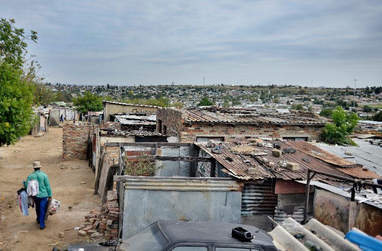 A man walks along the outer border of the impoverished Diepsloot township outside Johannesburg, South Africa, on April 16, 2014