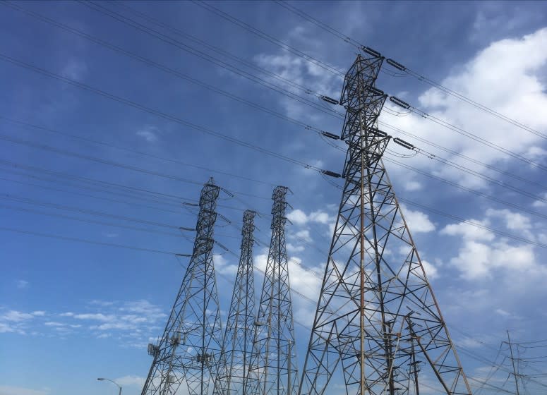 FILE - In this Saturday, Aug. 15, 2020, file photo, electrical grid transmission towers are seen in Pasadena, Calif. As if the pandemic and recession weren't bad enough, millions of Californians have been facing the recurring threats of abrupt blackouts during a heat wave in the nation's most populous state. (AP Photo/John Antczak, File)