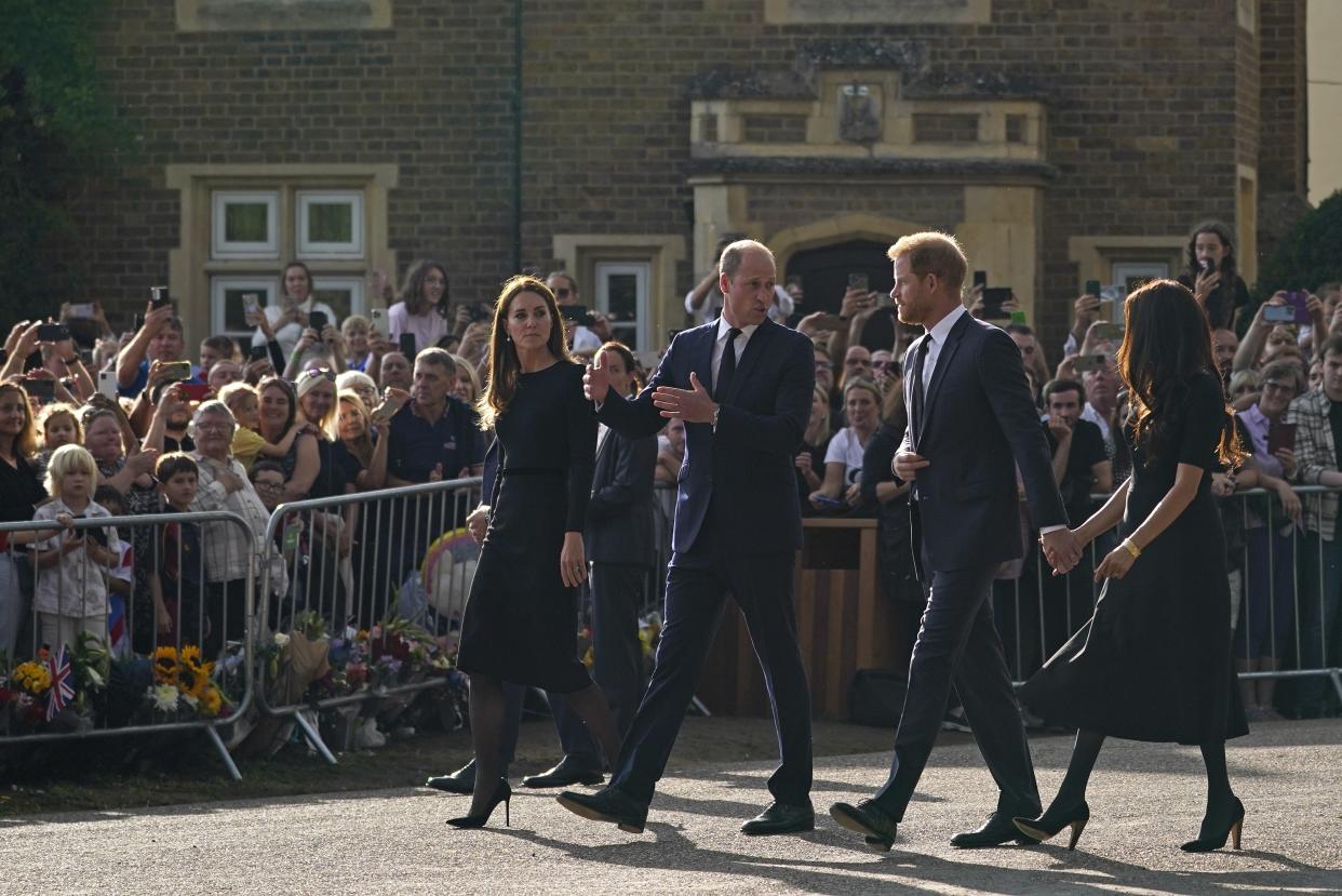 Britain's Prince William and Kate, Princess of Wales, left, and Britain's Prince Harry and Meghan, Duchess of Sussex walk to greet the crowds after viewing the floral tributes for the late Queen Elizabeth II outside Windsor Castle, in Windsor, England, Saturday, Sept. 10, 2022. 