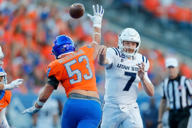 Utah State quarterback Spencer Petras (7) throws the ball under pressure from Boise State linebacker Marco Notarainni (53) in the first half of an NCAA college football game, Saturday, Oct. 5, 2024, in Boise, Idaho. . (AP Photo/Steve Conner) | Steve Conner