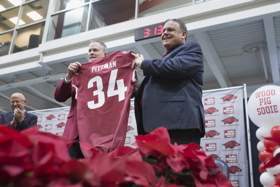 Coach Sam Pittman, right, and Hunter Yurachek, director of athletics, pose for pictures Monday, Dec. 9, 2019 in Fayetteville, Ark. Arkansas introduced former Georgia assistant Sam Pittman as its new head football coach. Pittman had a previous stop as an assistant with the Razorbacks and has spent much of his coaching career in the SEC. (Charlie Kaijo/The Northwest Arkansas Democrat-Gazette via AP)