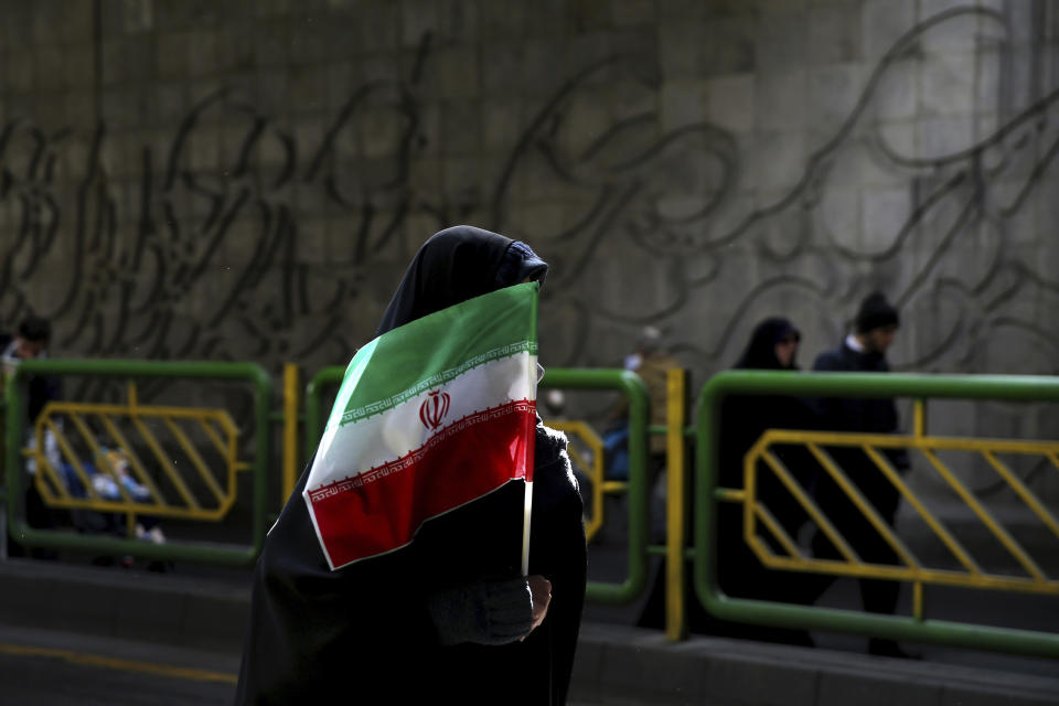 En esta imagen de archivo, tomada el 11 de febrero de 2016, una mujer iraní sostiene una bandera nacional durante una manifestación para conmemorar el 37mo aniversario de la Revolución Islámica, en Teherán, Irán. (AP Foto/Ebrahim Noroozi, archivo)