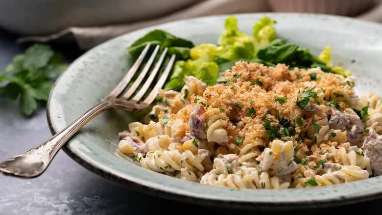 Tuna pasta salad with bread crumbs in a ceramic bowl with a fork