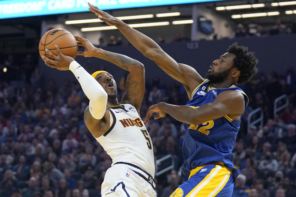 Denver Nuggets guard Kentavious Caldwell-Pope, left, shoots against Golden State Warriors forward Andrew Wiggins during the first half of an NBA basketball game in San Francisco, Friday, Oct. 21, 2022. (AP Photo/Jeff Chiu)