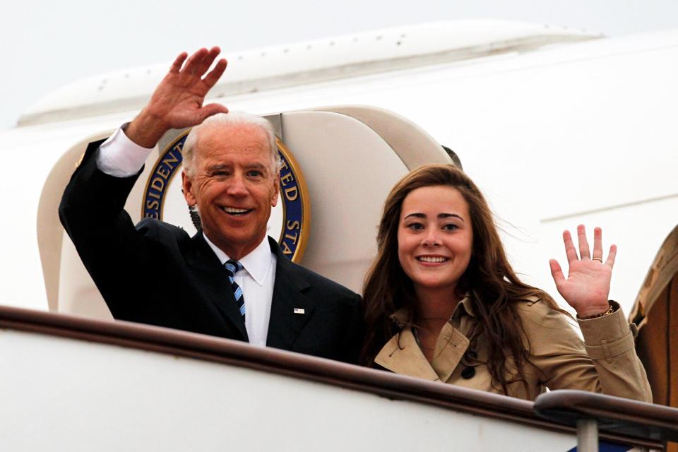 U.S. Vice President Joe Biden (L) waves with his granddaughter Naomi Biden as they walk out from Air Force Two upon arrival at the Beijing Capital International Airport on August 17, 2011 in Beijing, China.