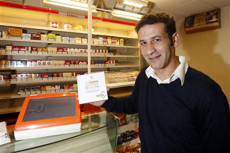 Ryad Boulanouar, President of the Financiere des Paiements Electroniques (FPE), poses next to a Nickel bank account machine during its presentation in a simulated tobacconist shop at a news conference in Paris October 16, 2013. REUTERS/Benoit Tessier