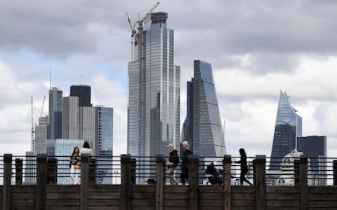 Pedestrians cross a bridge in the City of London