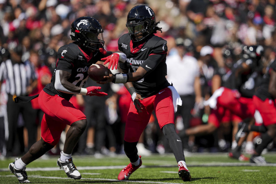 Cincinnati quarterback Emory Jones, right, hands the ball off to Myles Montgomery, left, during the first half of an NCAA college football game against Oklahoma, Saturday, Sept. 23, 2023, in Cincinnati. (AP Photo/Aaron Doster)