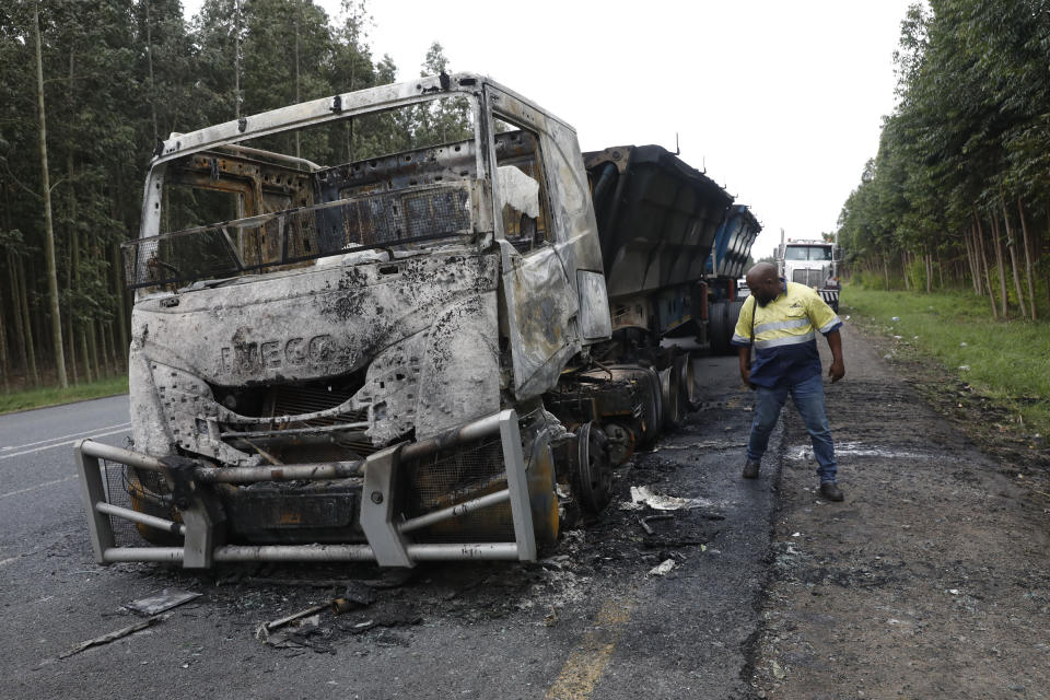 A man inspects a truck that was burned on the highway between Mpangeni and Nseleni in KwaZulu Natal, South Africa, Tuesday July 11, 2023. South Africa deployed the army in four of its provinces Friday July 14, 2023, after at least 21 trucks carrying goods were set on fire on national roads in various parts of the country since last weekend. (AP Photo)