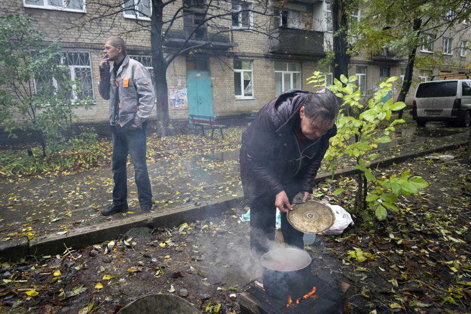 Local residents cook outdoor near their house in Bakhmut, the site of the heaviest battle against the Russian troops in the Donetsk region, Ukraine, Wednesday, Oct. 26, 2022. (AP Photo/Efrem Lukatsky)