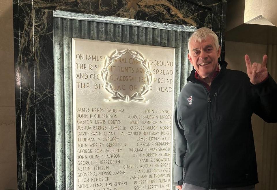 Former vice chancellor for student affairs Thomas Stafford stands in front of a plaque inside the Memorial Belltower