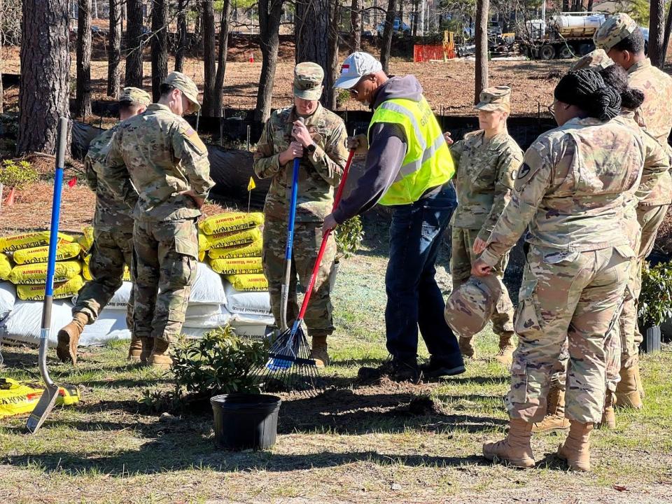 Sharrod Hairston with Fort Bragg Directorate of Public Works, center, gives volunteers instructions on how to plant the new azalea bushes Jan. 19, 2022, at Liberty Park, for Fort Bragg's Arbor Day volunteer event.