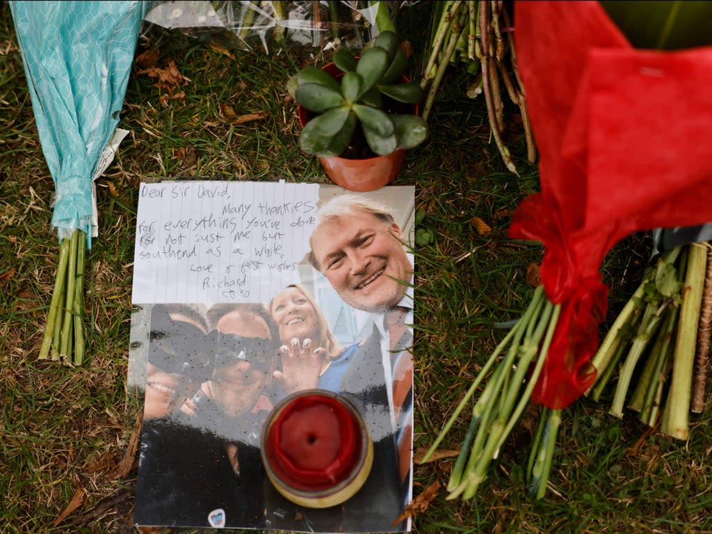 A photograph of David Amess among the floral tributes left at Belfairs Methodist Church (Tolga Akmen/AFP via Getty Images)