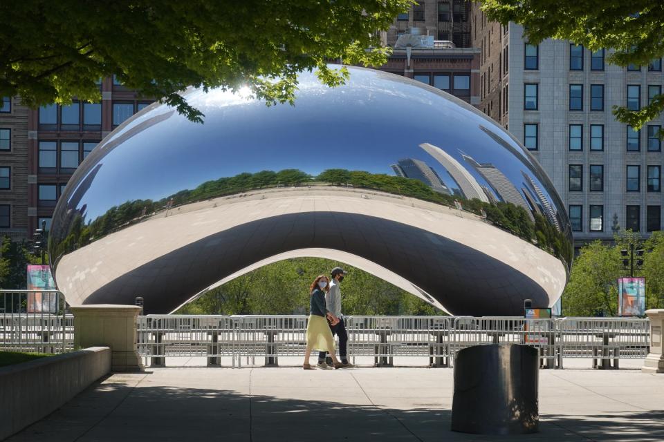 Visitors walk past the Cloud Gate, also known as "The Bean," sculpture in Millennium Park on June 15, 2020 in Chicago, Illinois