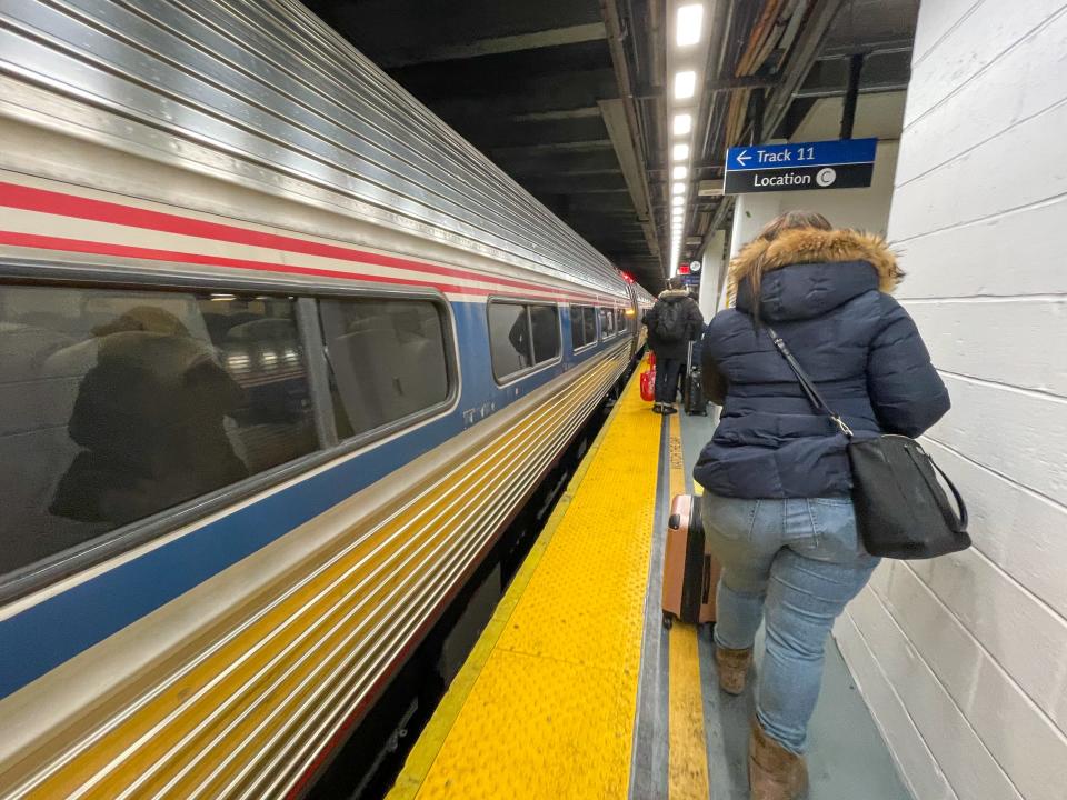 People walking past the Northeast Regional Amtrak train.