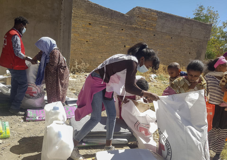 Ethiopian Red Cross Society (ERCS) volunteers hand over essential household items to internally displaced people sheltering in Mekele, the regional capital of the Tigray Region of northern Ethiopia Saturday, Dec. 12, 2020. Rare witness accounts are illuminating the shadowy conflict in Tigray, which is largely cut off from the outside world as fighting enters a fourth month in a region of 6 million people. (International Committee of the Red Cross via AP)