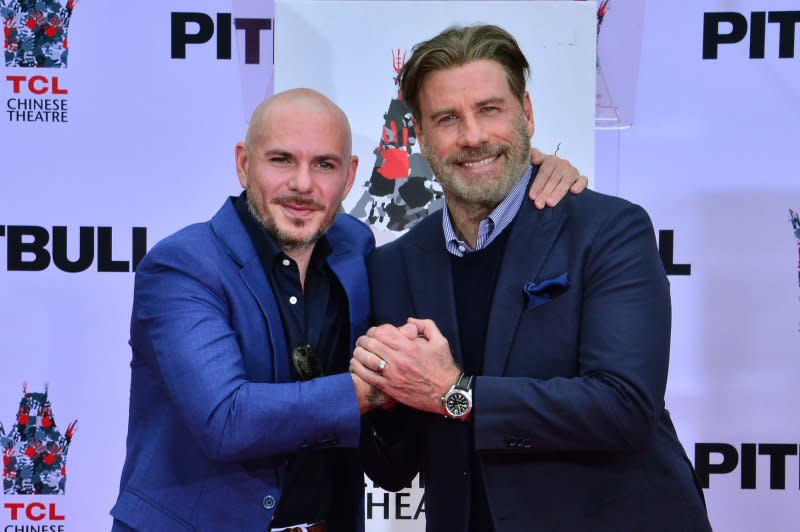 John Travolta (R) and Pitbull attend Pitbull's TCL Chinese Theatre hand and footprint ceremony in 2018. File Photo by Jim Ruymen/UPI