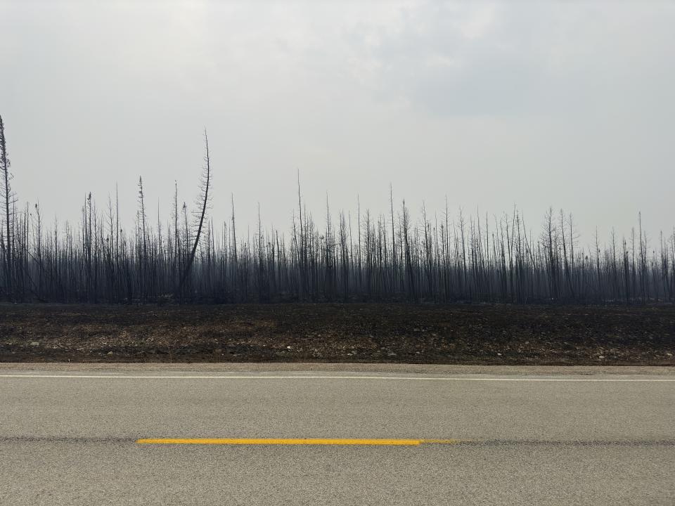 Damage from the wildfires is shown on Tuesday, Aug. 15, 2023 between Enterprise and Kakisa, Northwest Territories, Canada. Thousands of people in eight other communities, have already been forced to evacuate their homes, including the small community of Enterprise, where 80% of the town was destroyed. Officials said everyone made it out alive. (Ryan Planche via AP)