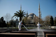 Dos trabajadores desinfectan un parque junto a la Mezquita Azul de Estambul (Turquía) el 21 de marzo. (Foto: Kemal Aslan / Reuters).