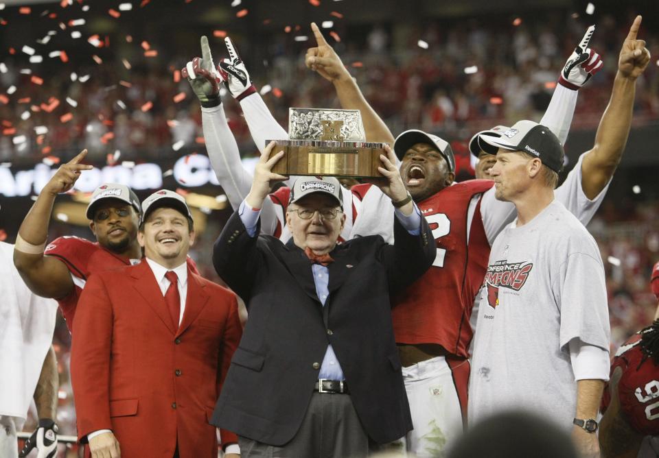 Arizona Cardinals owner, Bill Bidwill, flanked by Arizona Cardinals president Michael Bidwill, left, and head coach Ken Whisenhunt, holds the NFC Championship trophy after beating the Philadelphia Eagles Sunday, Jan. 18, 2009, at the University of Phoenix Stadium in Glendale.