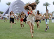 FILE - This April 13, 2012 file photo shows festivalgoers running toward the main stage at the 2012 Coachella Valley Music and Arts Festival in Indio, Calif. The Coachella music festival in Southern California has been postponed amid virus concerns. The festival is organized by concert promoter Goldenvoice, which released a statement Tuesday saying it will be rescheduled for two weekends in October. For most people, the new coronavirus causes only mild or moderate symptoms, such as fever and cough. For some, especially older adults and people with existing health problems, it can cause more severe illness, including pneumonia. The vast majority of people recover from the new virus. According to the World Health Organization, people with mild illness recover in about two weeks, while those with more severe illness may take three to six weeks to recover. (AP Photo/Chris Pizzello, File)