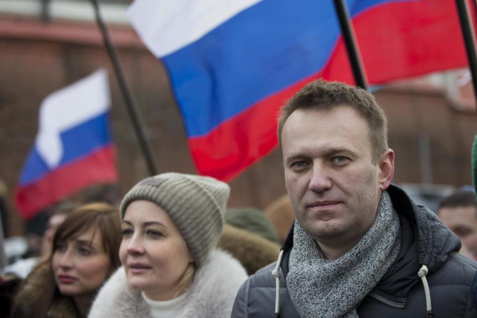 Russian opposition leader Alexei Navalny and his wife Yulia, second left, take part in a march in memory of opposition leader Boris Nemtsov in Moscow, Russia, Sunday, Feb. 26, 2017. Thousands of Russians take to the streets of downtown Moscow to mark two years since Nemtsov was gunned down outside the Kremlin. (AP Photo/Ivan Sekretarev)