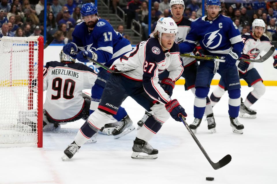 Columbus Blue Jackets defenseman Adam Boqvist (27) controls the puck in front of Tampa Bay Lightning left wing Alex Killorn (17) and center Steven Stamkos (91) during the second period of an NHL hockey game Tuesday, Jan. 10, 2023, in Tampa, Fla. (AP Photo/Chris O'Meara)