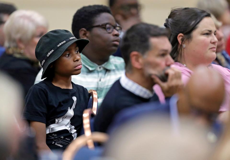 A young child listens as Daniel J. Flannery, professor and director of the Begun Center for Violence Prevention at Case Western Reserve University, speaks during the Akron Roundtable presentation on juvenile crime and gun violence Thursday.