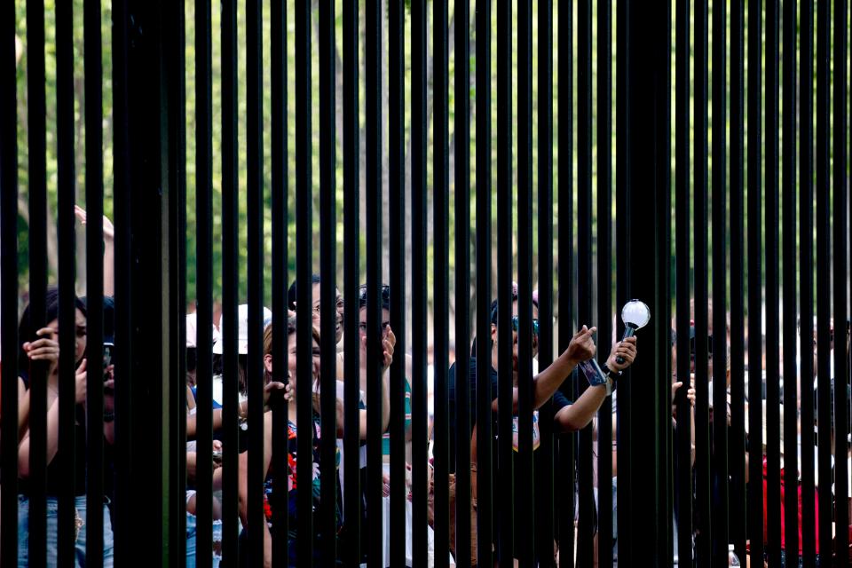 Fans of BTS reach through the fencing outside the White House in Washington, DC, on May 31, 2022.