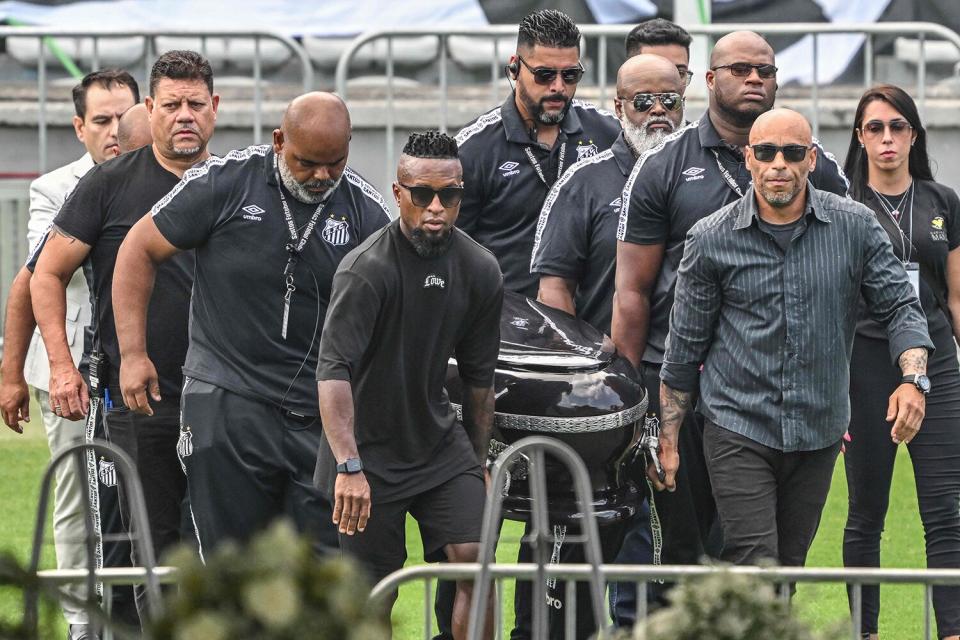 People headed by the son of late Brazilian football legend Pele, Edinho, transport his coffin into the Urbano Caldeira stadium in Santos, Sao Paulo, Brazil