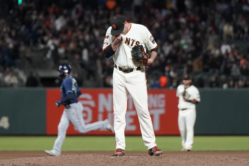 San Francisco Giants pitcher Luke Jackson, foreground, reacts after allowing a home run to Tampa Bay Rays' Christian Bethancourt, left, during the seventh inning of a baseball game in San Francisco, Monday, Aug. 14, 2023. (AP Photo/Jeff Chiu)