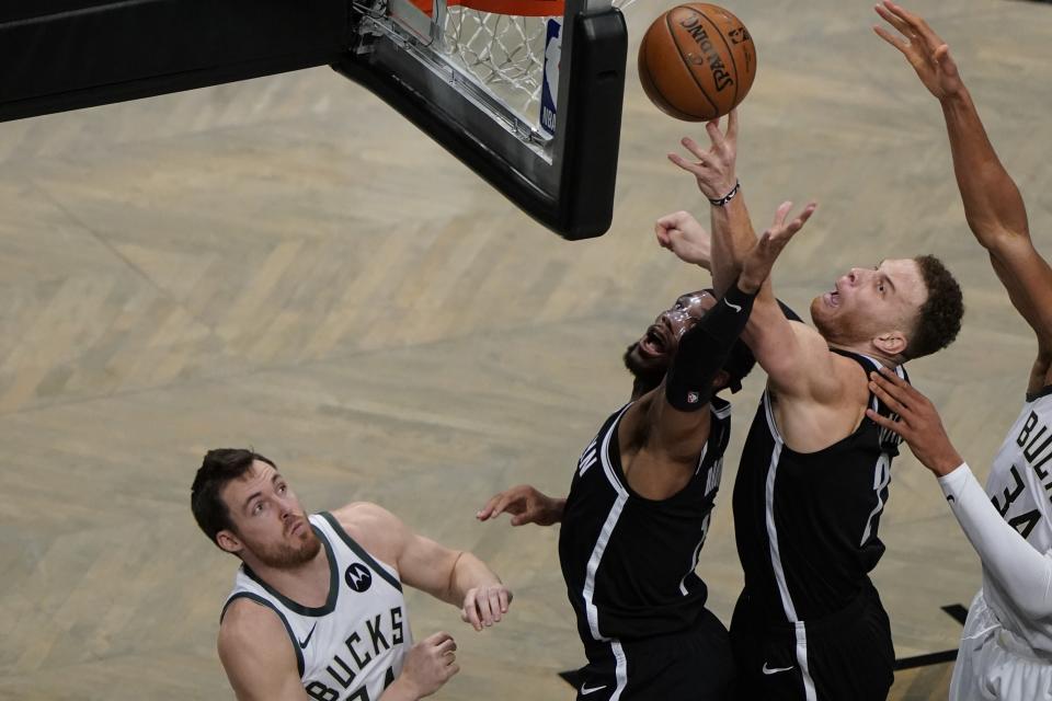 Brooklyn Nets' Blake Griffin, right, and Bruce Brown fight for control of the ball against Milwaukee Bucks' Pat Connaughton, left, during the first half of Game 7 of a second-round NBA basketball playoff series Saturday, June 19, 2021, in New York. (AP Photo/Frank Franklin II)